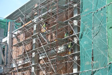 Seremban, Malezya - 05 Ağustos 2016: Malezya 'nın Seremban kentindeki şantiyede çalışırken emniyet kemeri ve yeterli güvenlik teçhizatı takan inşaat işçileri.