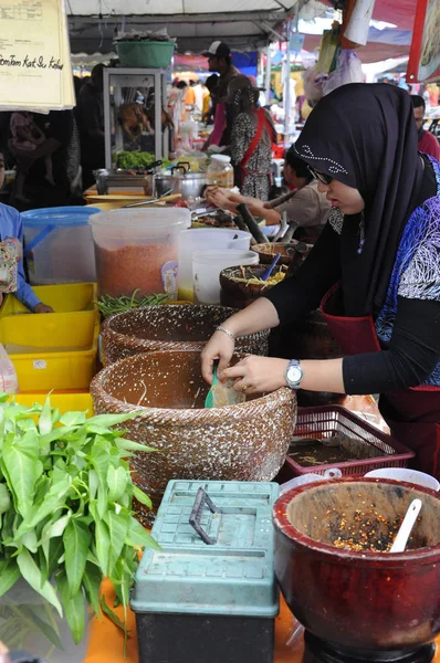 Kuala Lumpur, Malezya - 24 Ocak 2020: Sokak satıcıları halka yerel gıda satar. Yoldan geçenlere, kulübelerine uğramaları için seslendiler..