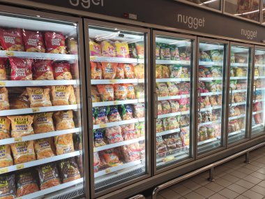 KUALA LUMPUR, MALAYSIA -JULY 17, 2019: Frozen foods displayed on the rack inside the large chiller in the supermarket. Displayed and arranged by the brand to make easy for the customer to select. 