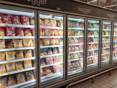 KUALA LUMPUR, MALAYSIA -JULY 17, 2019: Frozen foods displayed on the rack inside the large chiller in the supermarket. Displayed and arranged by the brand to make easy for the customer to select. 