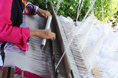 Kuala Lumpur, Malezya - 6 Eylül 2017: Bir kadın şarkı sözü örmek için geleneksel dokuma makineleri kullanıyor. Songket, yüksek kaliteli ve değerli geleneksel Malezya giysisidir..