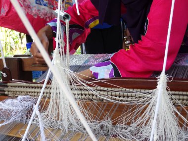 Kuala Lumpur, Malezya - 6 Eylül 2017: Bir kadın şarkı sözü örmek için geleneksel dokuma makineleri kullanıyor. Songket, yüksek kaliteli ve değerli geleneksel Malezya giysisidir..