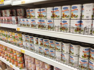 Kuala Lumpur, Malezya - 22 Aralık 2019: Şekerli süt ve buharlaştırılmış süt kutuları. Süpermarketin içindeki rafta satılık. Ana bileşen palmiye yağı tohumlarından yapılır..