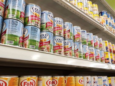 Kuala Lumpur, Malezya - 22 Aralık 2019: Şekerli süt ve buharlaştırılmış süt kutuları. Süpermarketin içindeki rafta satılık. Ana bileşen palmiye yağı tohumlarından yapılır..