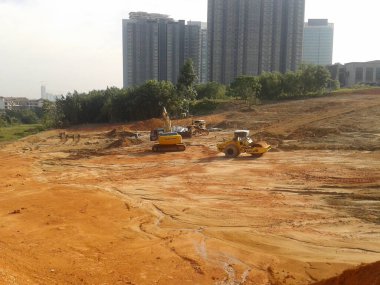 Kuala Lumpur, Malezya - 16 Temmuz 2017: İnşaat alanında toprak ve arazi temizliği yapan ağır makineler. Bina inşaatı gerekli seviyeleri almaya başlamadan önce yapılan çalışmalar. 