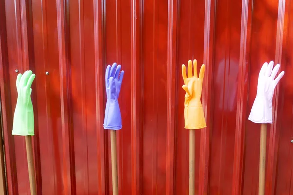 Colorful rubber hand gloves with red background