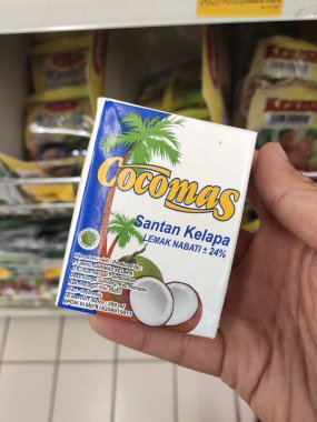 Kuala Lumpur, Malezya -14 Aralık 2019: İşlenmiş hindistan cevizi sütü kağıt kutuda paketlenmiş ve süpermarketin içindeki çelik bir rafta sergilenmektedir. Markaya göre sıralanır. 