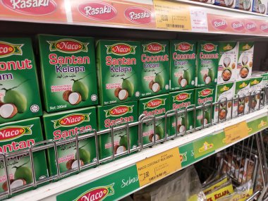 Kuala Lumpur, Malezya -14 Aralık 2019: İşlenmiş hindistan cevizi sütü kağıt kutuda paketlenmiş ve süpermarketin içindeki çelik bir rafta sergilenmektedir. Markaya göre sıralanır. 