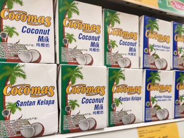 Kuala Lumpur, Malezya -14 Aralık 2019: İşlenmiş hindistan cevizi sütü kağıt kutuda paketlenmiş ve süpermarketin içindeki çelik bir rafta sergilenmektedir. Markaya göre sıralanır. 
