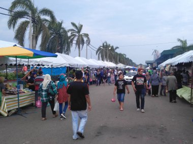 KUALA LUMPUR, MALAYSIA -MARCH 5, 2020: Street vendors sell local food to the public. They called to the passersby to stop by their booth.