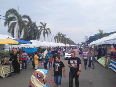 KUALA LUMPUR, MALAYSIA -MARCH 5, 2020: Street vendors sell local food to the public. They called to the passersby to stop by their booth.