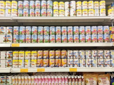 Kuala Lumpur, Malezya - 22 Aralık 2019: Şekerli süt ve buharlaştırılmış süt kutuları. Süpermarketin içindeki rafta satılık. Ana bileşen palmiye yağı tohumlarından yapılır..
