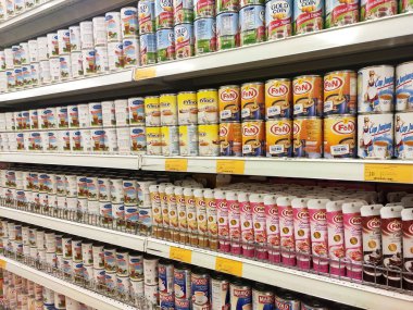 Kuala Lumpur, Malezya - 22 Aralık 2019: Şekerli süt ve buharlaştırılmış süt kutuları. Süpermarketin içindeki rafta satılık. Ana bileşen palmiye yağı tohumlarından yapılır..