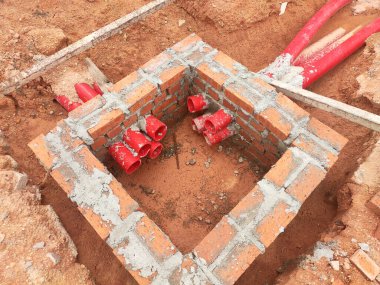 İnşaat alanında inşaat halindeki rögar kapağı. Altyapı mühendisi tasarımına dayanan işçilerin In-situ inşaatı.