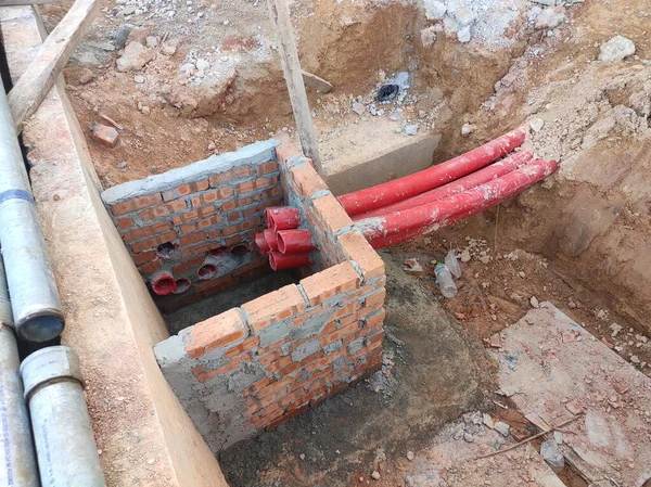 Utility services manhole under construction at the construction site. In-situ construction by workers based on infrastructure engineer design.