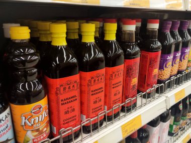 SEREMBAN, MALAYSIA -13 Mart 2020: Pişirme malzemesi olarak kullanılan çeşitli soya sosu türleri süpermarketlerde satışta. Bu malzemeyi yapmak için temel bileşen soya fasulyesidir..