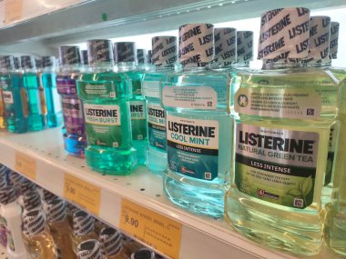 SEREMBAN, MALAYSIA -MARCH 9, 2020: Selective focused of liquid mouthwash product displayed for sale on the rack inside the supermarket.  clipart