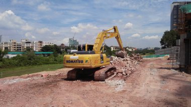 MALACCA, MALAYSIA - 5 Mart 2020: İnşaat alanında kazıcı makine. İnşaat alanında toprak çıkarmak ve malzeme taşımak için kullanılıyor. Hidrolik bir kovayla güçlendirilmiş..  