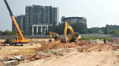 MALACCA, MALAYSIA - 5 Mart 2020: İnşaat alanında kazıcı makine. İnşaat alanında toprak çıkarmak ve malzeme taşımak için kullanılıyor. Hidrolik bir kovayla güçlendirilmiş..  