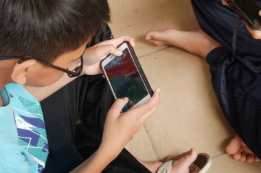 SEREMBAN, MALAYSIA - Mart 01, 2020: Çocuklar cep telefonlarında Mobil Efsaneler oynuyorlar. Bu oyun çevrimiçi ya da çevrimdışı oynansa da popüler.