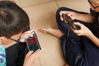 SEREMBAN, MALAYSIA - Mart 01, 2020: Çocuklar cep telefonlarında Mobil Efsaneler oynuyorlar. Bu oyun çevrimiçi ya da çevrimdışı oynansa da popüler.