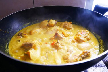 Malezyalı geleneksel aşçı Ayam Masak Lemak Chili Padi. Su, hindistan cevizi sütü, biberli zerdeçal ve su karışımı ile pişirilmiş tavuk..