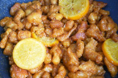 Küçük parçalara ayrılmış tavuk eti ve yumurta unu karışımı. Sıcak tavaya koy. Pişip çıtır çıtır olana kadar kızgın yağla kızartılır. Baharat olarak portakallı..