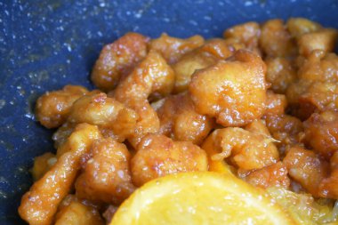 Küçük parçalara ayrılmış tavuk eti ve yumurta unu karışımı. Sıcak tavaya koy. Pişip çıtır çıtır olana kadar kızgın yağla kızartılır. Baharat olarak portakallı..