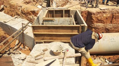 İnşaat alanında inşaat halindeki rögar kapağı. Altyapı mühendisi tasarımına dayanan işçilerin In-situ inşaatı.