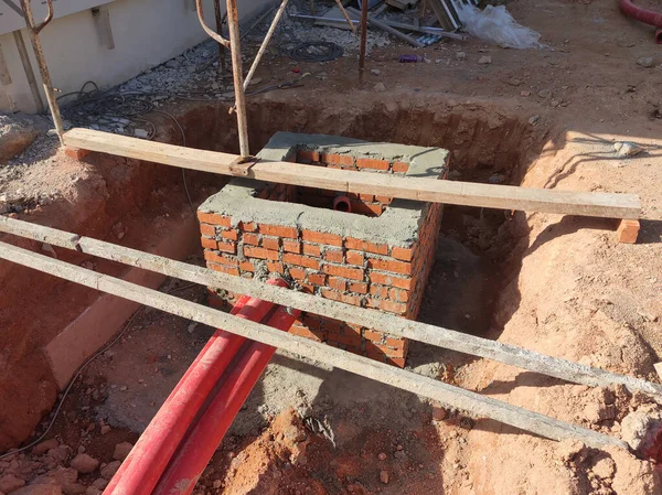 Utility services manhole under construction at the construction site. In-situ construction by workers based on infrastructure engineer design.