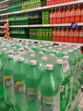 KUALA LUMPUR, MALAYSIA - 16 Mart 2020: Hafif içecekler veya karbonatlı içecekler büyük süpermarketin içindeki raflarda satılığa çıkarıldı ve istiflendi. Müşterinin satın almasını kolaylaştırmak için markaya göre sıralanır.