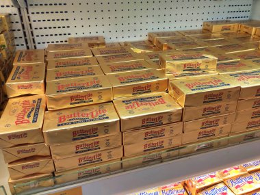 SEREMBAN, MALAYSIA -APRIL 13, 2020: Kare paketlemedeki tereyağı süpermarketin içindeki soğutucu raflarda sergilenmektedir. Tereyağı, süt ve kremanın yağ ve protein bileşenlerinden yapılan bir süt ürünüdür.. 