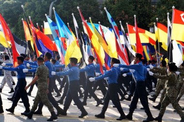PUTRAJAYA, MALAYSIA - 31 AĞUSTOS 2019: Malezyalı gençler, Malezya devlet bayraklarını tutarken yolda yürüyen üniformalarla tamamlandı. Üniformalar Malezya 'daki çeşitli üniformaları temsil ediyordu.