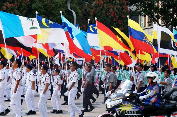 PUTRAJAYA, MALAYSIA - 31 AĞUSTOS 2019: Malezyalı gençler, Malezya devlet bayraklarını tutarken yolda yürüyen üniformalarla tamamlandı. Üniformalar Malezya 'daki çeşitli üniformaları temsil ediyordu.