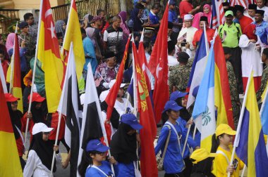 PUTRAJAYA, MALAYSIA -31 AĞUSTOS 2019: Malezya Bağımsızlık Yürüyüşü sırasında Malezya devletinin bayraklarını tutarken çeşitli etnik gruplardan Malezyalı gençler.  
