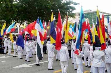 PUTRAJAYA, MALAYSIA -31 AĞUSTOS 2019: Malezya Bağımsızlık Yürüyüşü sırasında Malezya devletinin bayraklarını tutarken çeşitli etnik gruplardan Malezyalı gençler.  