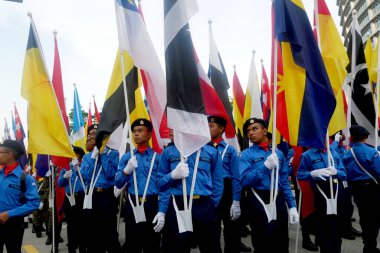 PUTRAJAYA, MALAYSIA -31 AĞUSTOS 2019: Malezya Bağımsızlık Yürüyüşü sırasında Malezya devletinin bayraklarını tutarken çeşitli etnik gruplardan Malezyalı gençler.  