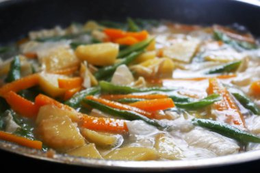 Uzun fasulye, patates, tofu, tofu derisi ve havuç kızartılır ve hindistan cevizi sütüyle pişirilir. Sebzelerin tazeliğini ve beslenmesini sağlamak için hızlı pişirin..