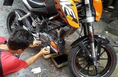 SEREMBAN, MALAYSIA -3 AĞUSTOS 2019: Mekanikler atölyedeki motor yağlarını tamir ediyor ve değiştiriyorlar. Her motosiklet bir tamirci tarafından çalıştırılacak..