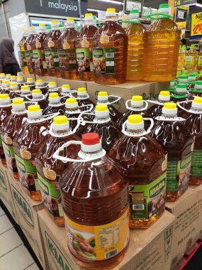 SEREMBAN, MALAYSIA -APRIL 24, 2020: Süpermarkette satılmak üzere işlenmiş palmiye tohumundan yapılan pişirme yağı. Müşterinin seçmesini kolaylaştırmak için markaya göre sıralanır. 