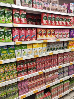 KUALA LUMPUR, MALAYSIA - 20 Mart 2020: Meyve aromalı meyve suyu süpermarketlerin içindeki rafta sergilenmek üzere karton kutuda sergilenmektedir. Müşterilerin seçmesini sağlamak için markalara göre sıralanır.
