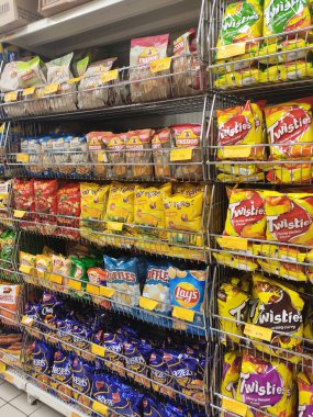 KUALA LUMPUR, MALAYSIA -APRIL 26, 2020: Markette raflarda satılık paketlenmiş çeşitli ürünler ve abur cuburların seçici odak noktası. Herkesin kendi fiyat etiketi var.. 