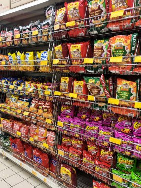 KUALA LUMPUR, MALAYSIA -APRIL 26, 2020: Markette raflarda satılık paketlenmiş çeşitli ürünler ve abur cuburların seçici odak noktası. Herkesin kendi fiyat etiketi var.. 