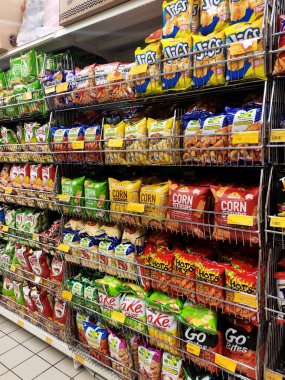 KUALA LUMPUR, MALAYSIA -APRIL 26, 2020: Markette raflarda satılık paketlenmiş çeşitli ürünler ve abur cuburların seçici odak noktası. Herkesin kendi fiyat etiketi var.. 