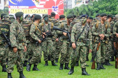 SEREMBAN, MALAYSIA - 31 Ağustos 2016: Üniformalı ve tamamen silahlı Malezyalı askerler. Malezya Bağımsızlık Günü geçit töreninden sonra gayri resmi bir yerde duruyoruz..