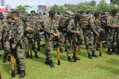 SEREMBAN, MALAYSIA - 31 Ağustos 2016: Üniformalı ve tamamen silahlı Malezyalı askerler. Malezya Bağımsızlık Günü geçit töreninden sonra gayri resmi bir yerde duruyoruz..