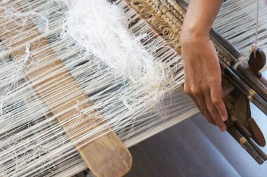 KUALA LUMPUR, Malezya - Kasım 29. 2018: Bir kadın şarkı sözü dokumak için geleneksel dokuma makineleri kullanıyor. Songket, yüksek kaliteli ve değerli geleneksel Malezya giysisidir..