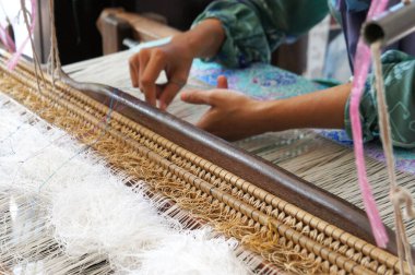 KUALA LUMPUR, Malezya - Kasım 29. 2018: Bir kadın şarkı sözü dokumak için geleneksel dokuma makineleri kullanıyor. Songket, yüksek kaliteli ve değerli geleneksel Malezya giysisidir..