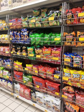 KUALA LUMPUR, MALAYSIA -APRIL 26, 2020: Markette raflarda satılık paketlenmiş çeşitli ürünler ve abur cuburların seçici odak noktası. Herkesin kendi fiyat etiketi var.. 