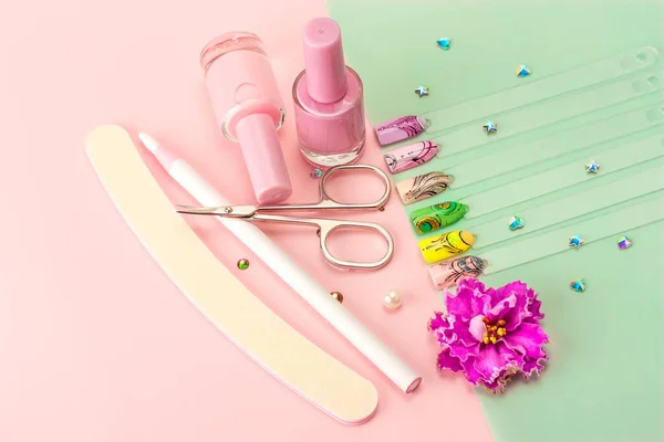 Manicure accessories and nail Polish on a colored background.
